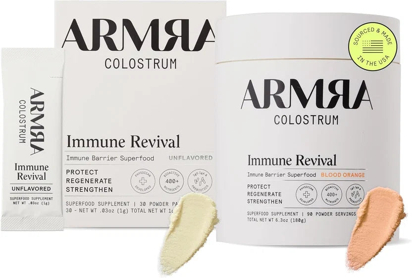 ARMRA Colostrum Immune Revival powder supplement packaging shown on a white background, including a large tub, a smaller box, a single sachet, a yellow 'Sourced & Made in the USA' badge, and two powder swatches in pale yellow and peach.