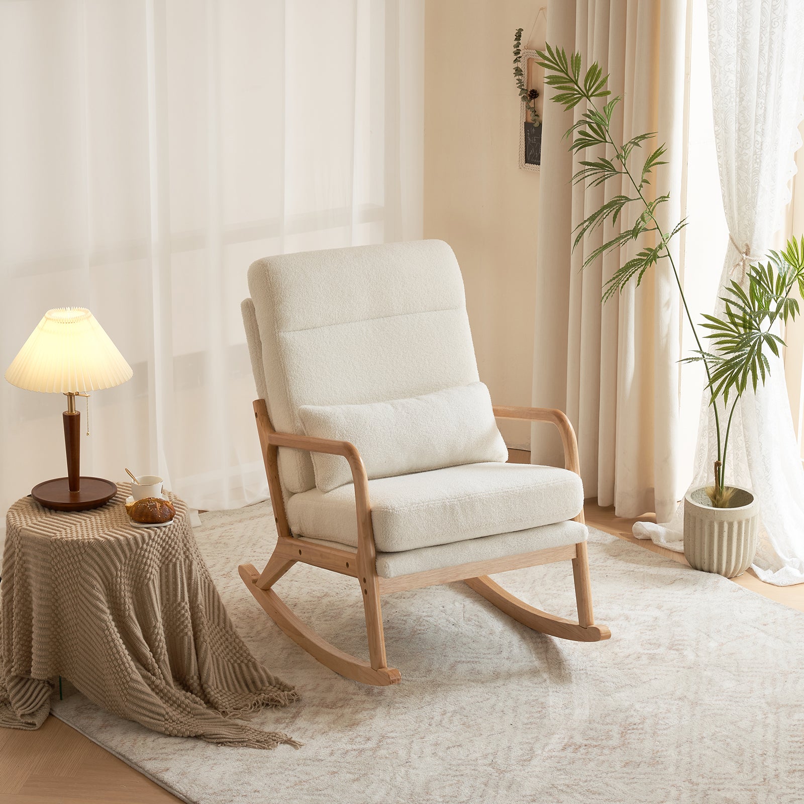 White rocking chair in a cozy living room with a side table and lamp.